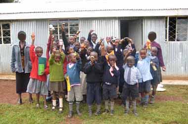 FKC children outside their classrooms with gifts
